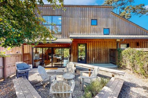 a wooden house with a patio and a table and chairs at Ocean Pines Lodge in Sea Ranch