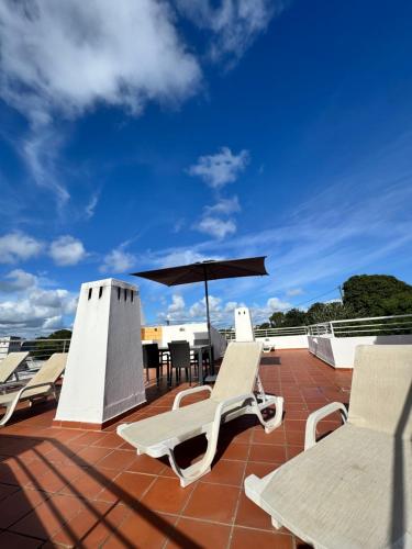 a patio with chairs and an umbrella on a roof at Casa Julio-Rooftop Terrace & Pool 5 Min to Beach in Carvoeiro
