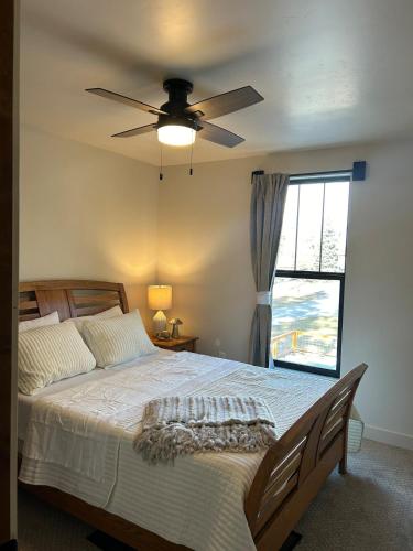 a bedroom with a bed with a ceiling fan and a window at The Farmhouse in Darby
