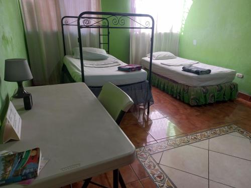 two beds in a room with a table and chairs at Casa MONTOCO 114 in Managua