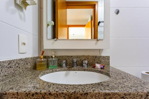 a bathroom counter with a sink and a mirror at AP Df Plaza varandão in Brasília