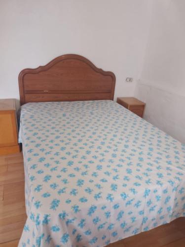 a bedroom with a bed with a blue and white bedspread at Rooms Melide in Melide