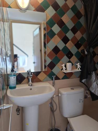 a bathroom with a sink and a toilet and a mirror at loft B in Fez