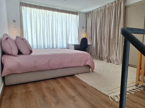 a bedroom with a bed with pink sheets and a window at loft B in Fez