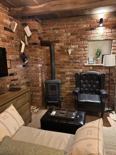 a living room with a brick wall with a stove at Podroom LauMarYvo in Dugo Selo