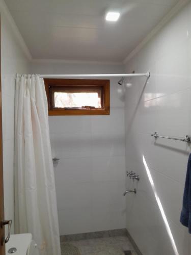 a bathroom with a shower curtain and a window at Mi CASA in Sierra de los Padres