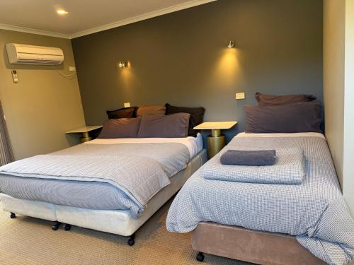 a bedroom with two beds and a table in it at Motel Strahan in Strahan