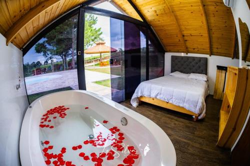 ein Badezimmer mit einer Badewanne voller roter Rosen in der Unterkunft Chalé do Rista in Suzano