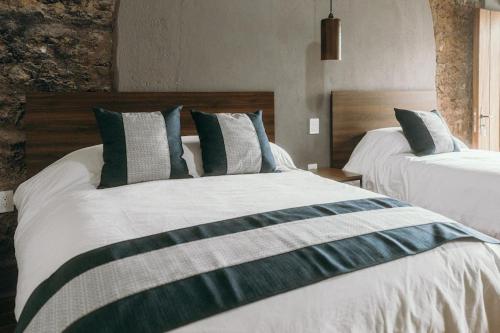 a bedroom with two beds with green and gray pillows at El Mesón de Don José in La Mesa