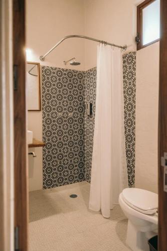 a bathroom with a shower curtain and a toilet at El Mesón de Don José in La Mesa