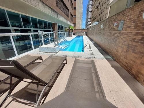 a swimming pool in the middle of a building at Book Santos Mar, Sol e Conforto no Unique 710 e 810 in Santos