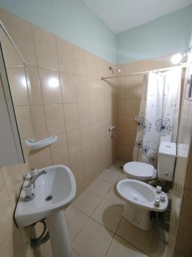 a bathroom with a white sink and a toilet at Jujuy 555 Nqn in Neuquén