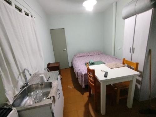 a small bathroom with a sink and a bed at Jujuy 555 Nqn in Neuquén