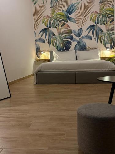 a bedroom with a bed with a mural of plants at SUITE LUX apulia in Massafra