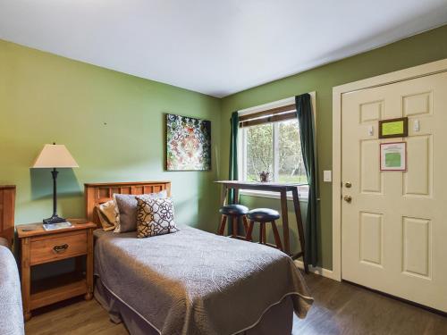 a bedroom with a bed and a table and a window at Elk Meadow Cabins 13B Bears Den - Single Room in Orick