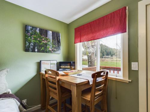 a dining room table with two chairs and a window at Elk Meadow Cabins 17B Gold Rush - Single Room in Orick