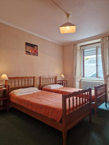 a bedroom with two beds and a window at Hôtel de la Gare - Morlaix in Morlaix
