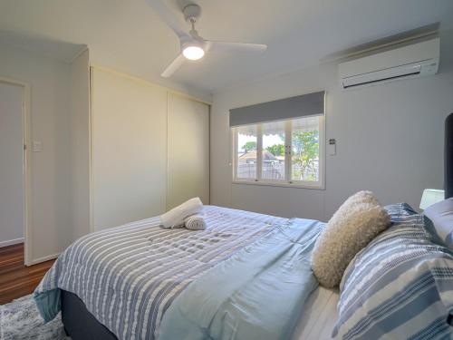 a bedroom with a bed and a window at Ocean Getaway in Hervey Bay