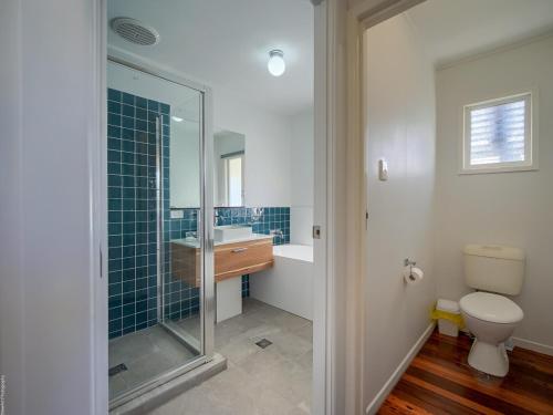 a bathroom with a shower and a toilet and a sink at Ocean Getaway in Hervey Bay