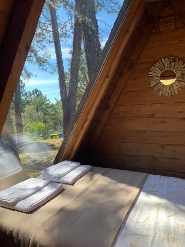 a bed in a room with a large window at Micro Cabana Rotativa in Bragança
