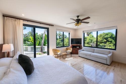 a bedroom with a large bed with a ceiling fan at Hacienda Todos Los Santos in Todos Santos