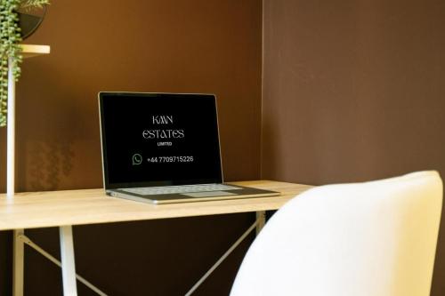 a laptop computer sitting on top of a wooden desk at Hotel Style Room within Reading in Reading