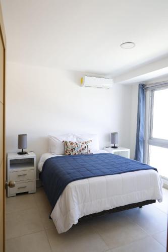 a bedroom with a blue and white bed and a window at Villa Labuena in Punta Cana