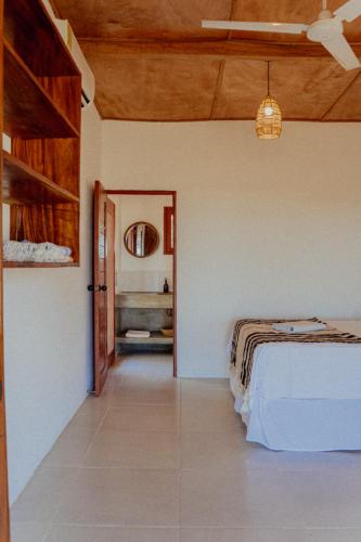 a bedroom with a bed and a hallway with a mirror at Echoes Surf Casitas in Mechapa