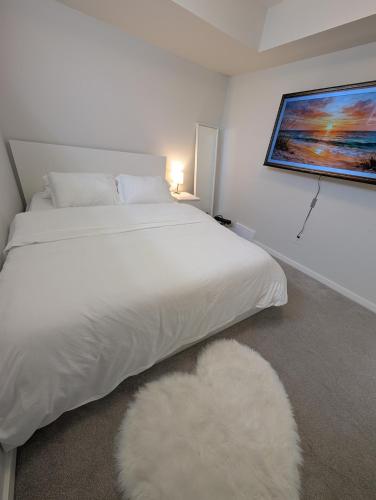 a bedroom with a white bed and a white rug at Modern Private Suite - Quiet & Central Winnipeg in Winnipeg