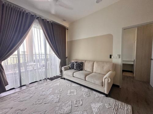 a living room with a couch and a large window at ANTARA Muji Serenity Condo in Putrajaya