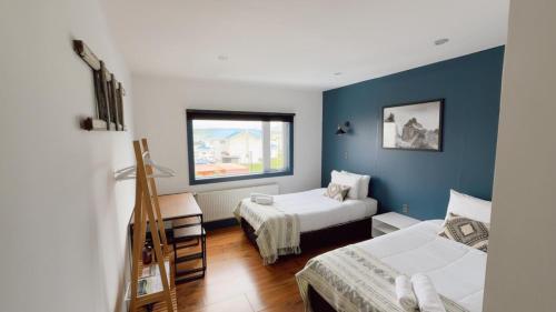 a bedroom with two beds and a window at Pristine Patagonia Hotel in Puerto Natales