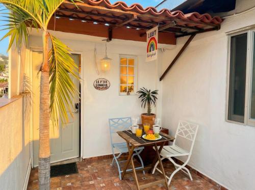 a table and chairs on a patio with a door at Le Petit Bonheur - Breeze & Rooftop - 3 min Beach in Puerto Vallarta