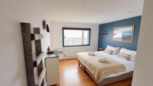 a bedroom with a large bed with blue walls at Pristine Patagonia Hotel in Puerto Natales
