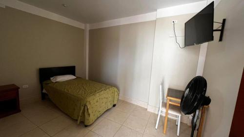 a bedroom with a bed and a flat screen tv at Hostal Bon in Nazca