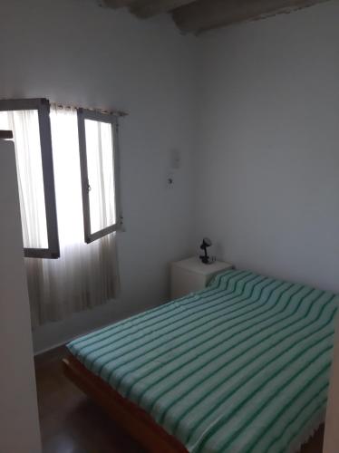 a bedroom with a green bed with two windows at El Viejo Nogal in Gómez