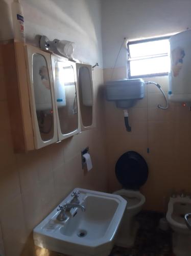 a bathroom with a sink and a toilet and a mirror at El Viejo Nogal in Gómez