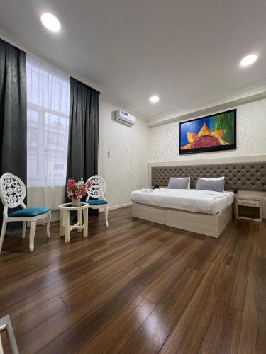 a bedroom with a large bed and two chairs at Empire Hotel Baku F1 view in Baku