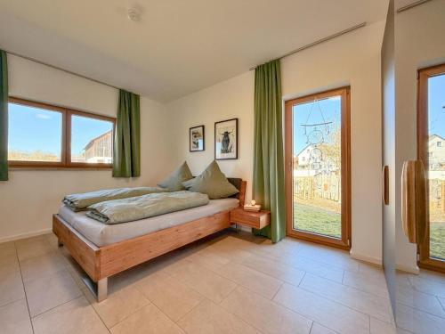 ein Schlafzimmer mit einem Bett und zwei Fenstern in der Unterkunft Fonse in Pettendorf