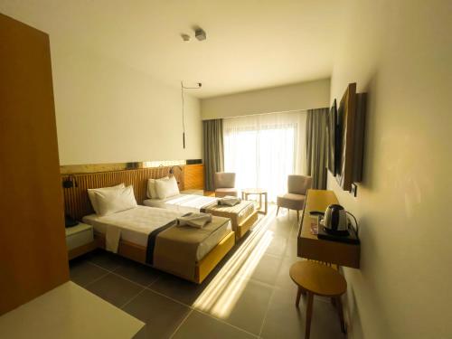 a hotel room with a bed and a desk at Blue Inn Hotel in Gökçeada