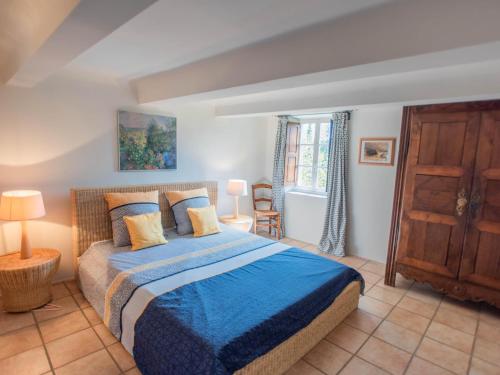 a bedroom with a bed with a blue blanket at Le Mas dormant in Fayence