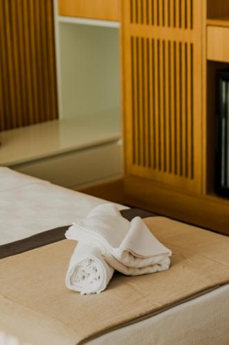 a white towel sitting on top of a bed at Blue Inn Hotel in Gökçeada