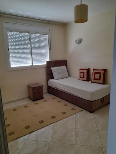 a small bedroom with a bed and a window at ma chambre in Casablanca