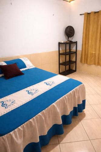 a bedroom with a bed with a blue and white blanket at Chácara Sossego in Viçosa do Ceará