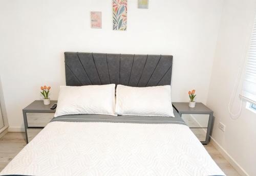 a bedroom with a bed with two night stands at Room cerca al aeropuerto #4 in Bogotá