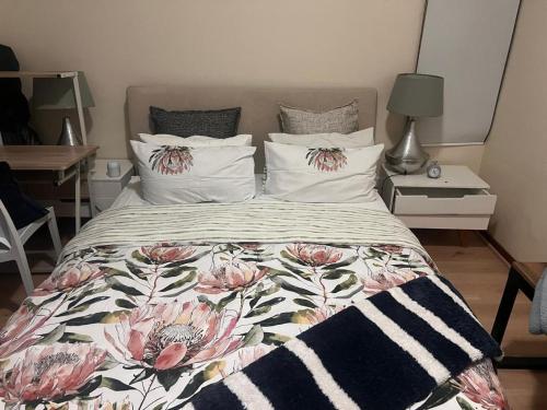 a bed with a floral comforter and pillows at 3 bed Cluster home in Sandton in Sandton