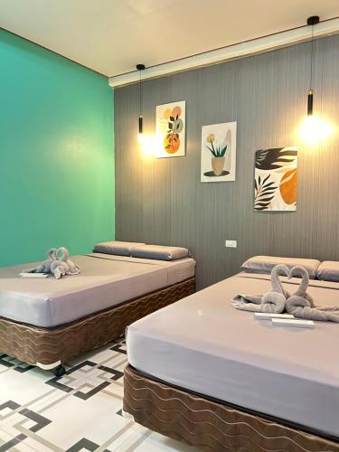 a room with two beds with towels on them at Baybay Hostel in Siquijor