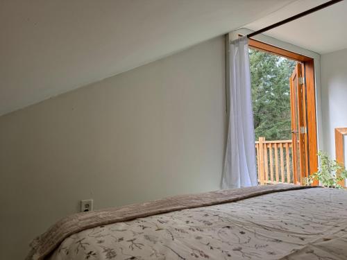 a bedroom with a bed and a window at Kinsol Hideaway in Shawnigan Lake