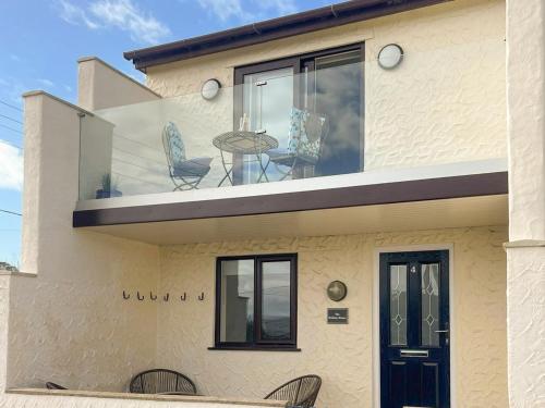 a house with chairs and a table on a balcony at The Holiday House in Benllech