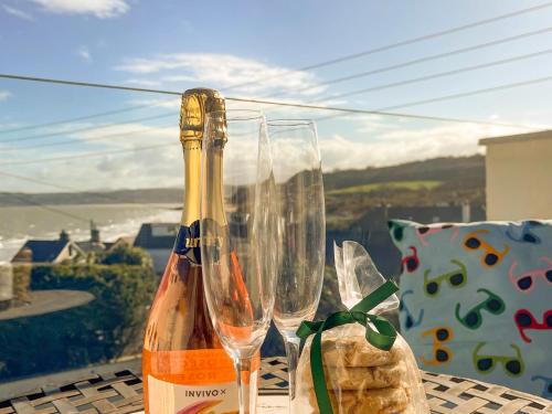 a bottle of champagne and two glasses on a table at The Holiday House in Benllech