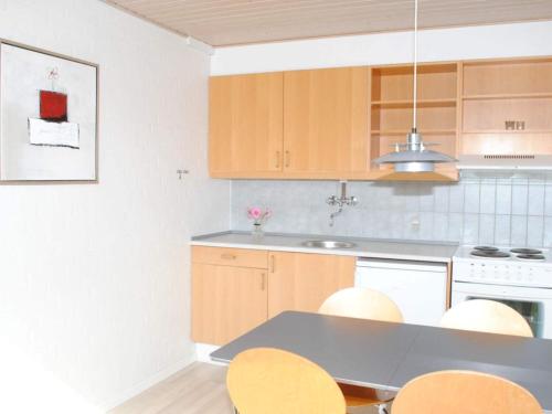 a kitchen with wooden cabinets and a table and chairs at 4 person holiday home in Allinge in Allinge
